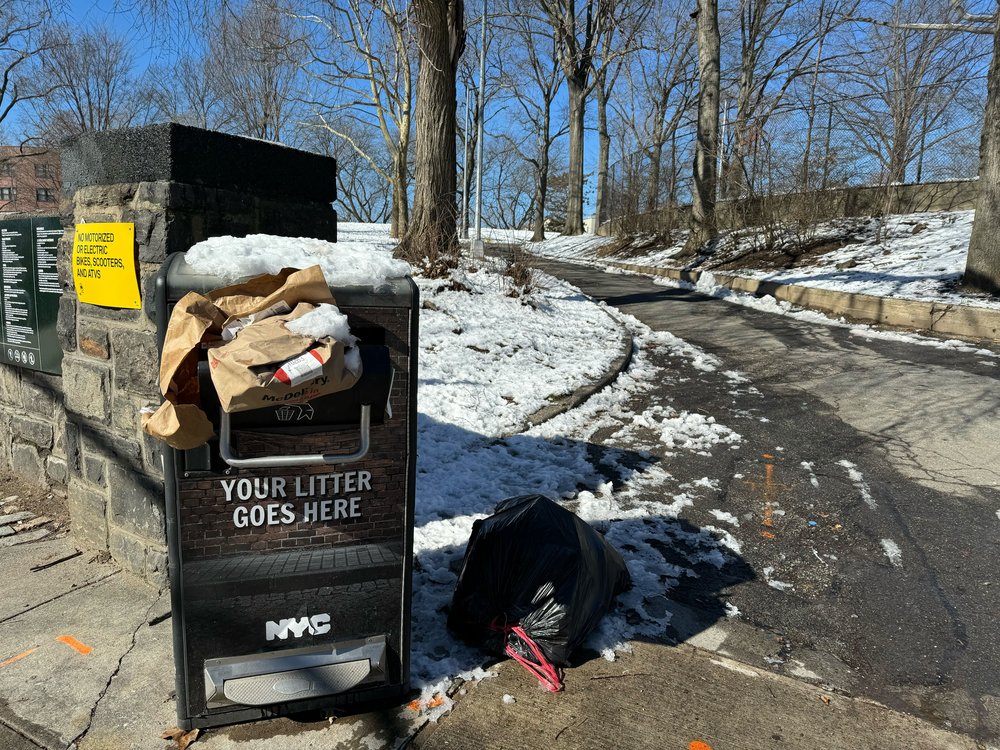 An overflowed garbage can in Claremont Park.