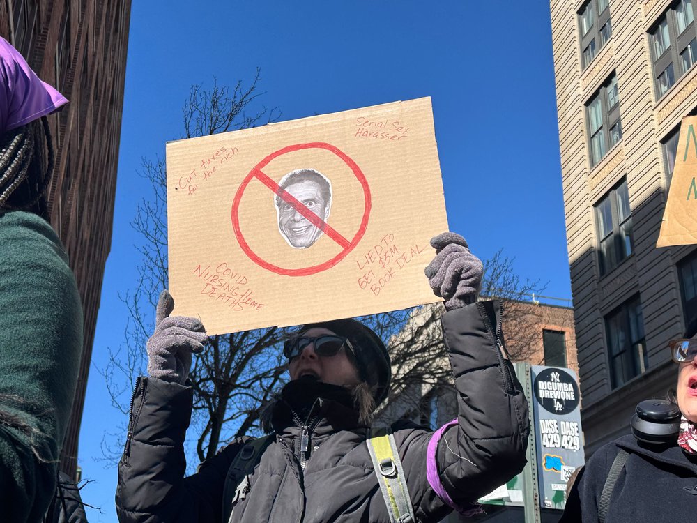 A protester displays a sign outside an endorsement rally for Andrew Cuomo for mayor.