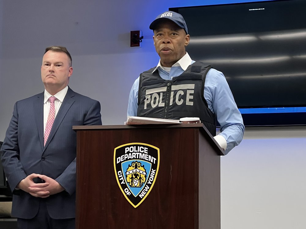 Mayor Eric Adams stands at an NYPD podium.