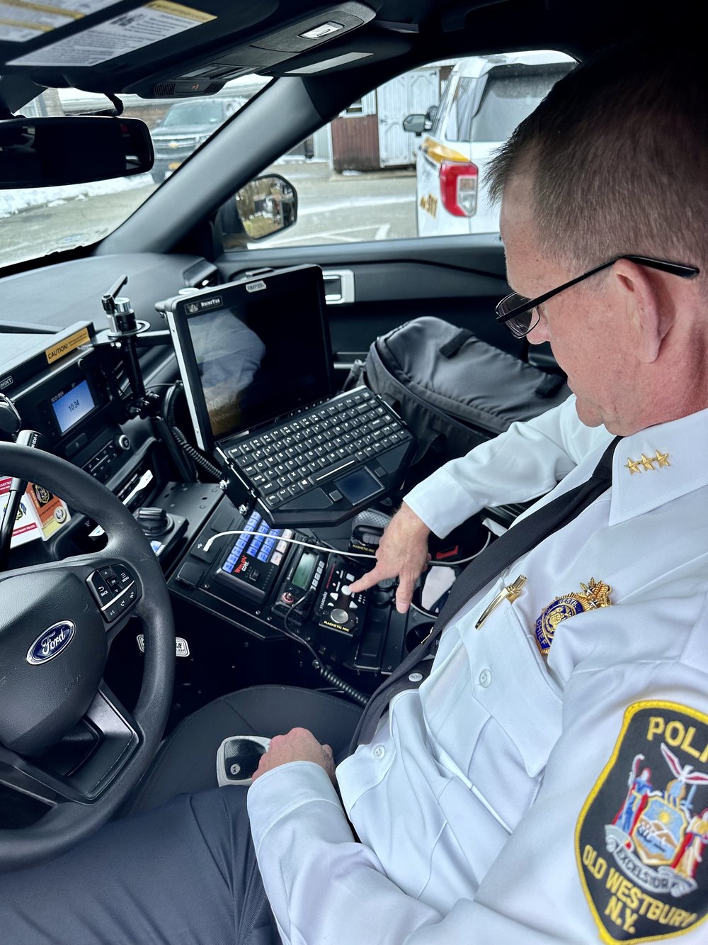 Old Westbury Police Chief Stuart Cameron shows off the button officers can press to fire a GPS dart from their police cruisers.