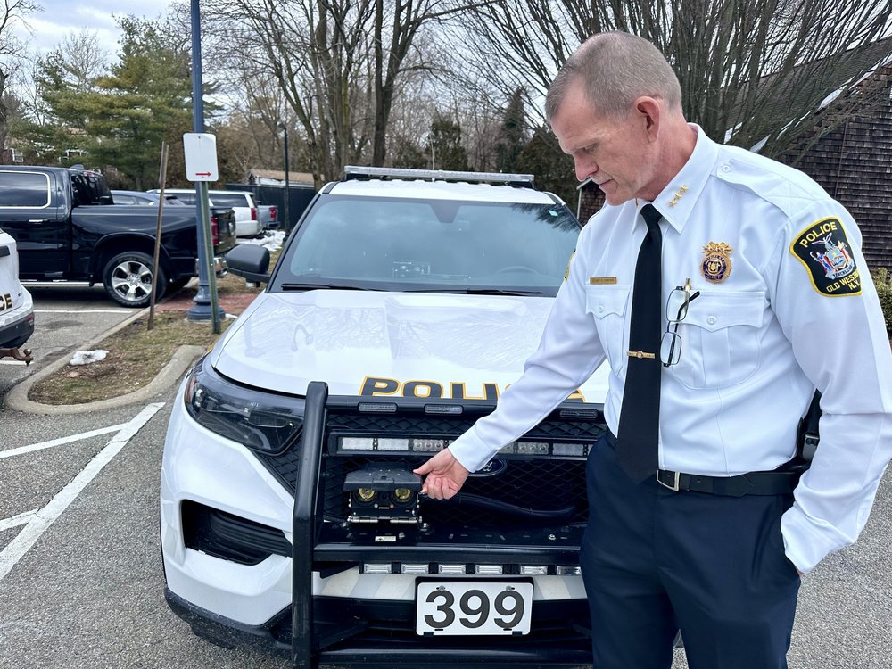 Old Westbury Police Chief Stuart Cameron shows where GPS darts are fired from on police cruisers.