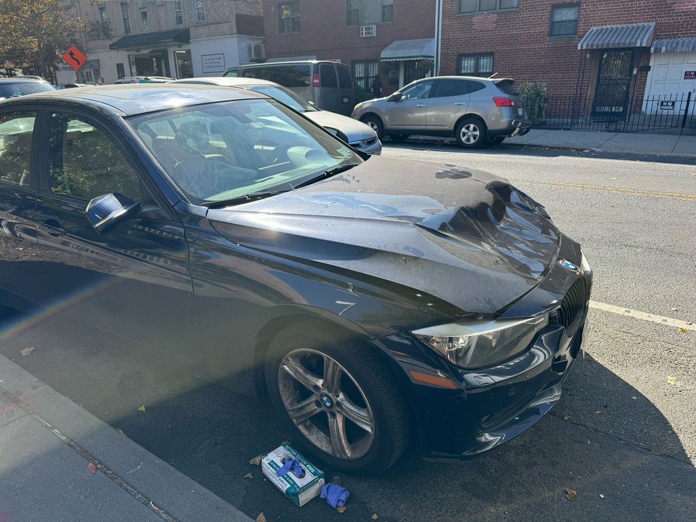 The dented BMW on which a witness says Amanda Servedio landed after the pickup truck driver struck her.