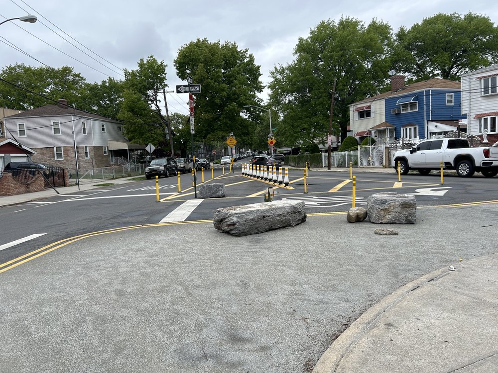 An intersection with bollards and fresh markings.