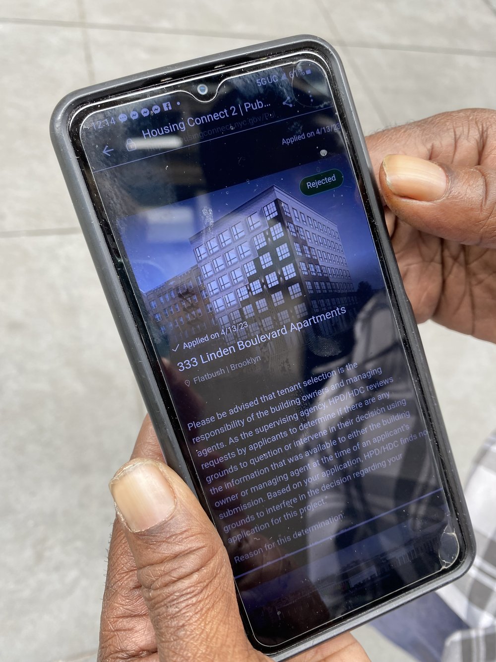 Darren Whitney shows the affordable housing lottery website on his phone.
