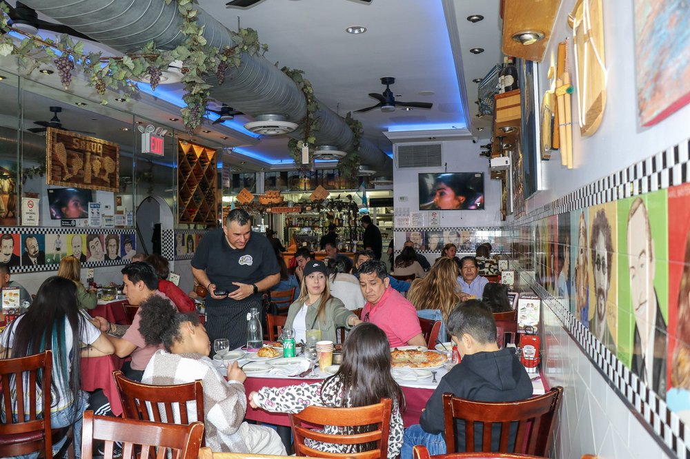 A server stands in a crowded dining room.