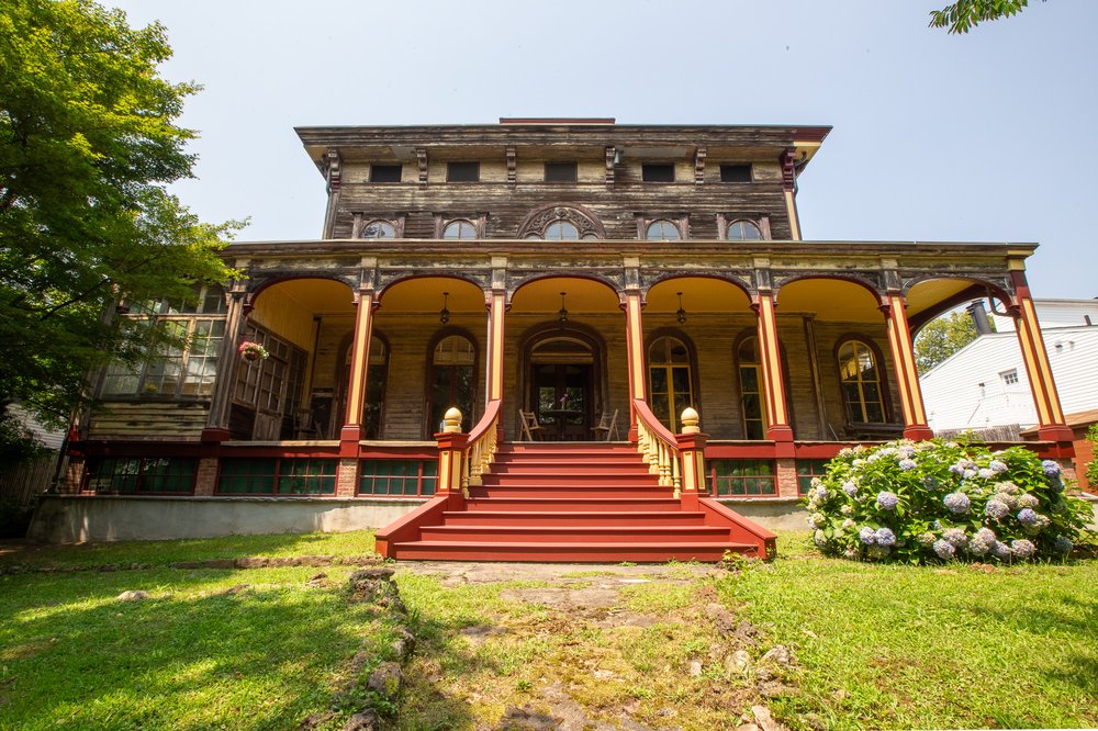 The front of the house sits atop a crest that slopes down a half acre landscaped garden to busy Richmond Road.