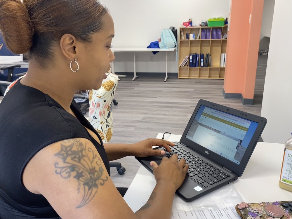 Malika Butler, 37, receives a brand new laptop from the nonprofit LIFT, that she says will help her son who will attend a trade school in the fall.