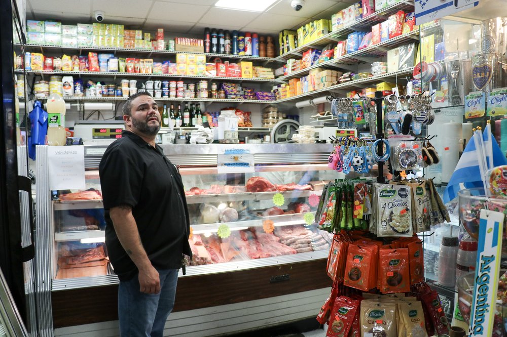 A man stands in a deli.