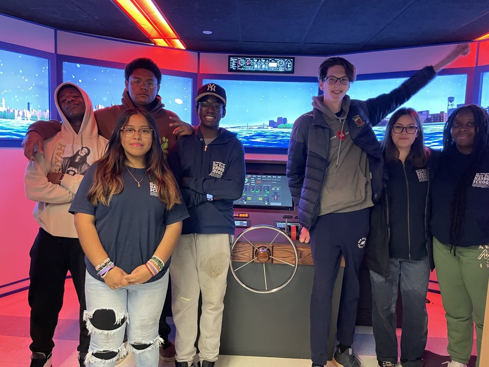 Students in the afterschool activity, the Waterfront Club, learn to drive boats in New York waterways using a boat simulation deck.