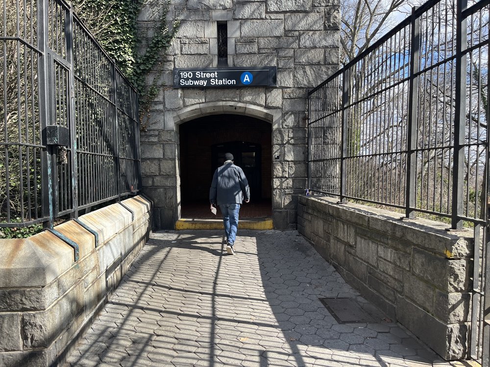 A Tudor Gothic stone building acts as the top entrance to the 190th Street station.