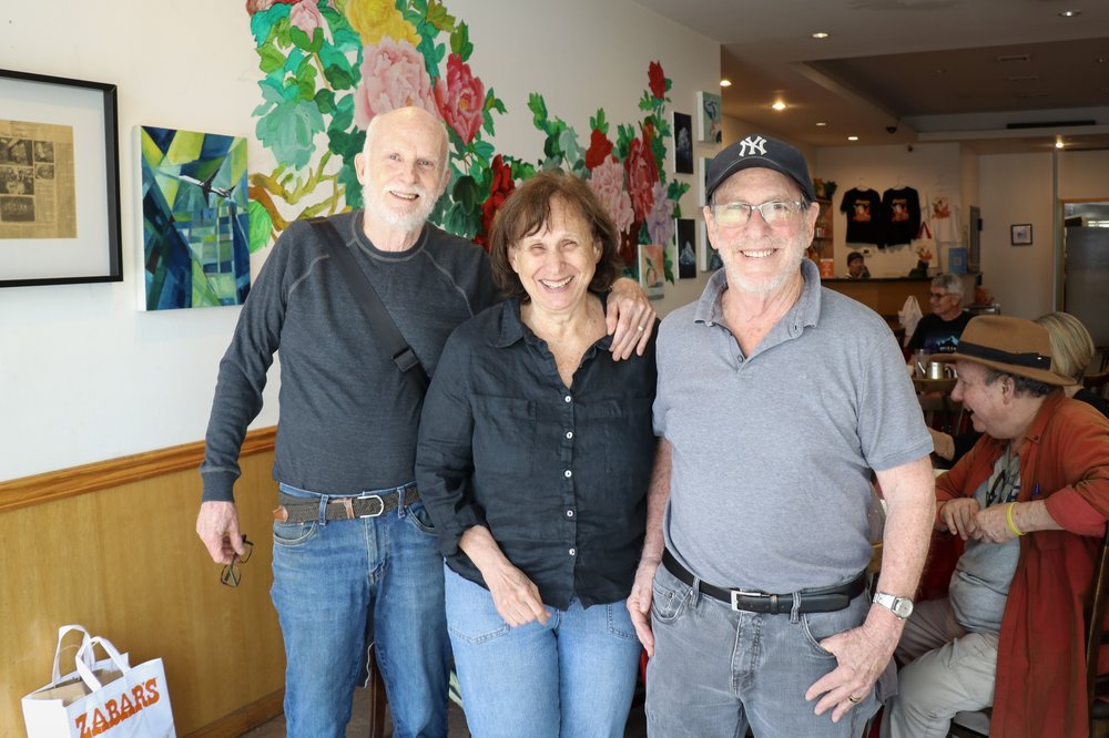 Three people pose for a picture at Little Pepper restaurant.