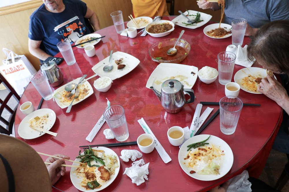 Empty plates on a red tablecloth in a restaurant.
