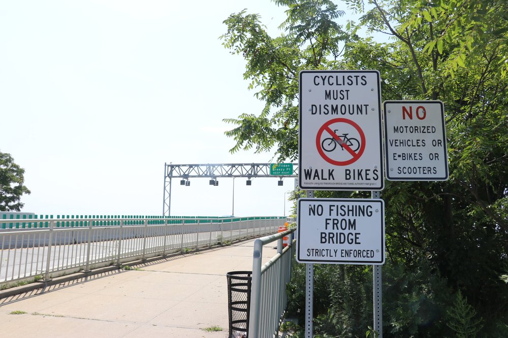 Signage warns riders both that bicycling across the Marine Parkway Bridge isn't allowed and that fishing from the bridge isn't allowed.