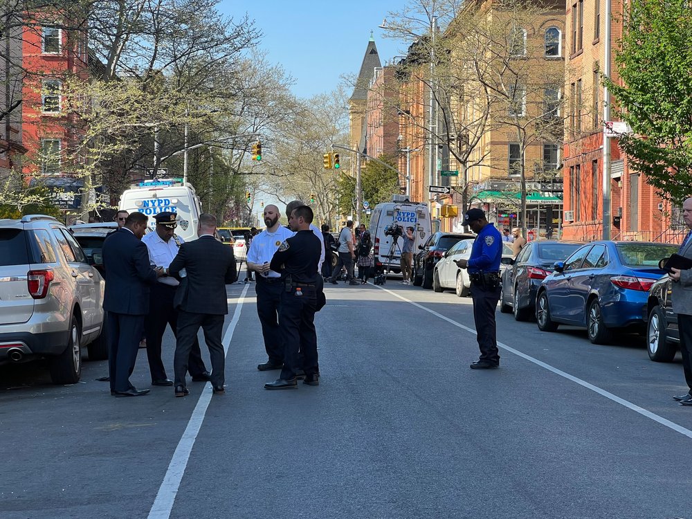 Officers gather near the scene of a fatal shooting in Brooklyn on Thursday.