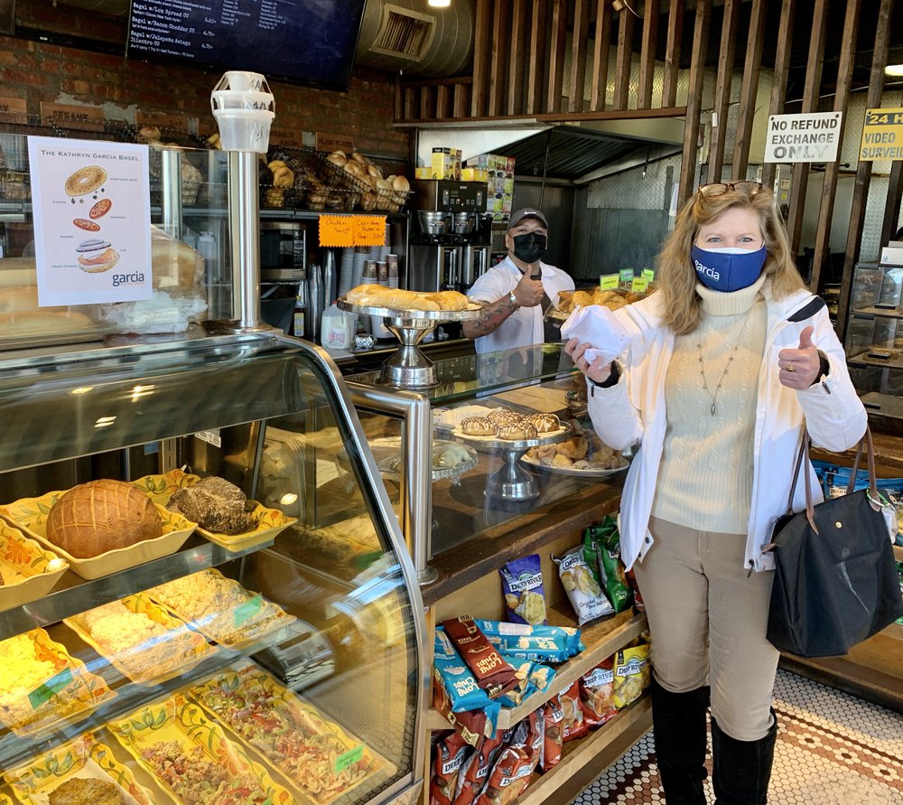 A photo of Kathryn Garcia holding a bagel at Brownstone Bagels
