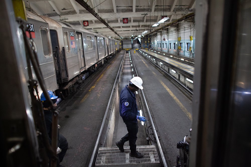 Workers cross tracks at 240th Street Yard.
