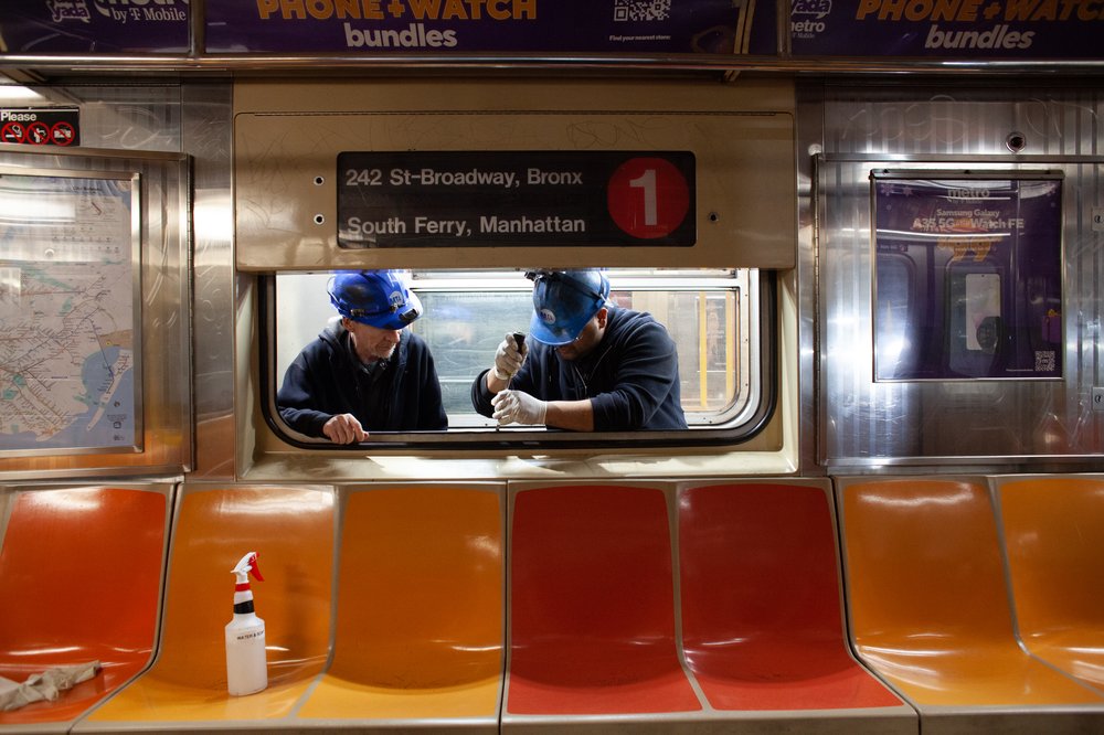 Two workers in a subway car.