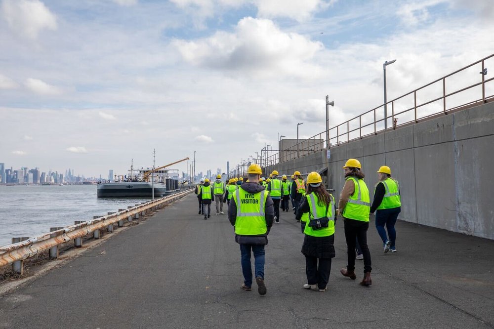 A group of people wearing vests and hard hats