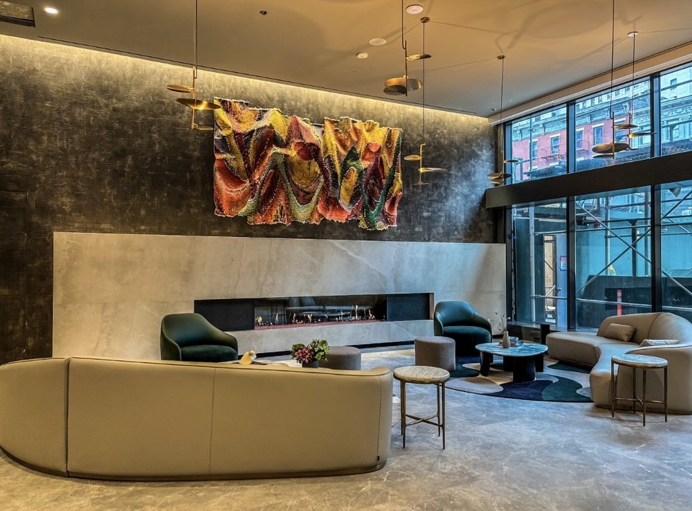Inside the new lobby at 25 Water Street in Manhattan, featuring lounge seating and a fireplace.
