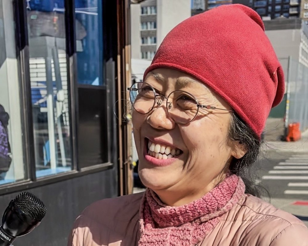 A woman smiling in front of a laundromat