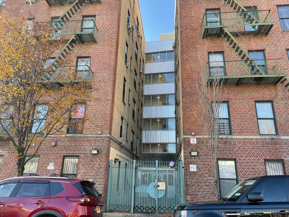 Outside the Mott Haven building where three people were found dead with multiple stab wounds Sunday morning