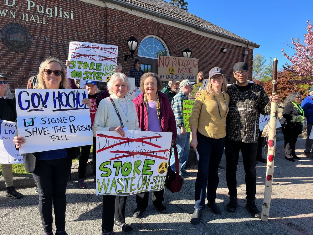Protesters hold signs with nuclear symbols reading "store waste on-site" and "no radioactive waste in our air and water."