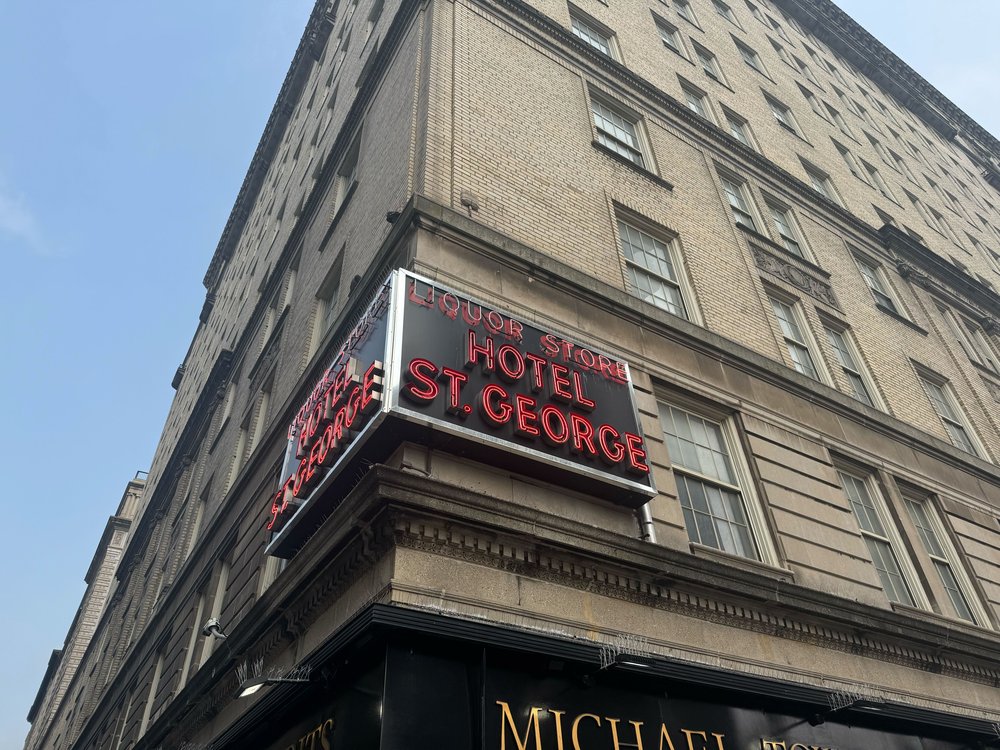 A sign that says "Hotel St. George" on the outside of the building that houses the Clark Street subway station.