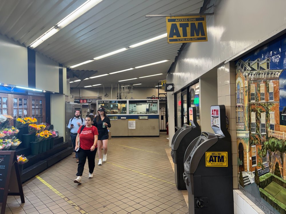 The lobby of the Clark Street subway station in Brooklyn heights with a sign for an ATM machine.