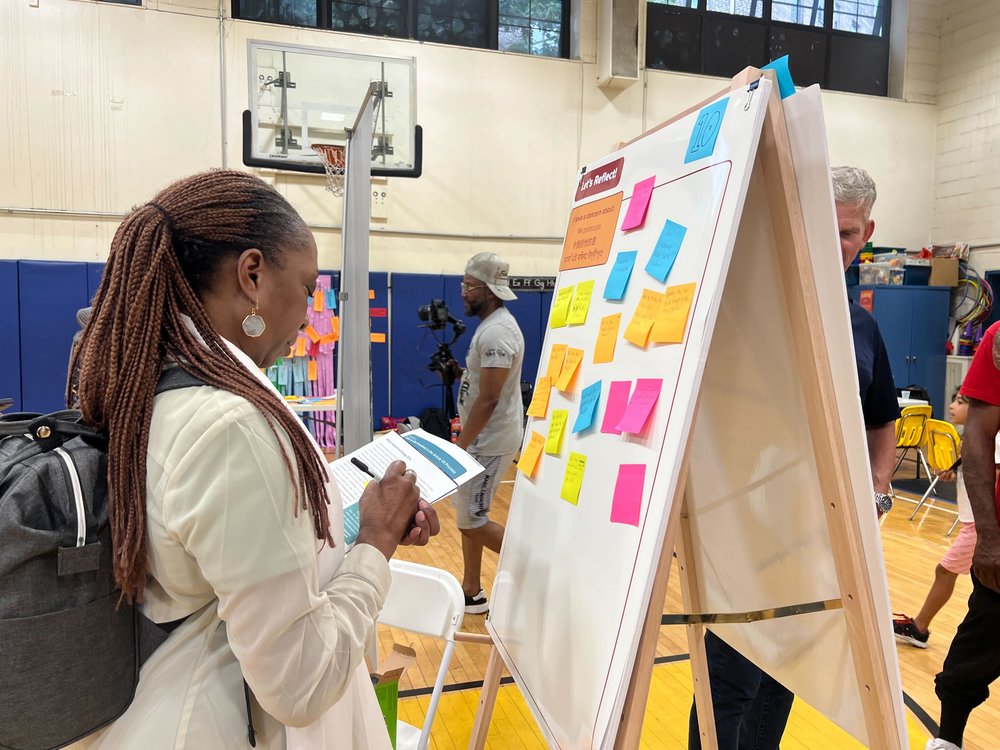 Vanessa Jones-Hall, a resident of the nearby Astoria Houses, writes a concern about the potential wind farm construction plans at a community meeting Wednesday.