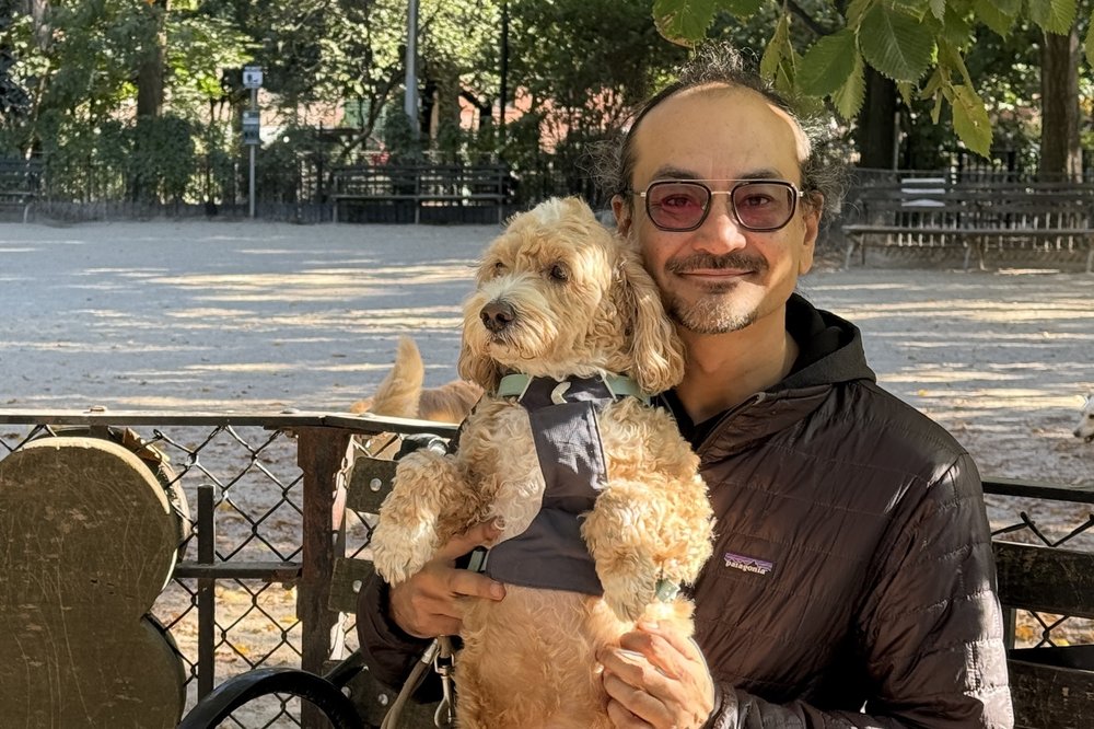 A man with his dog on his lap.