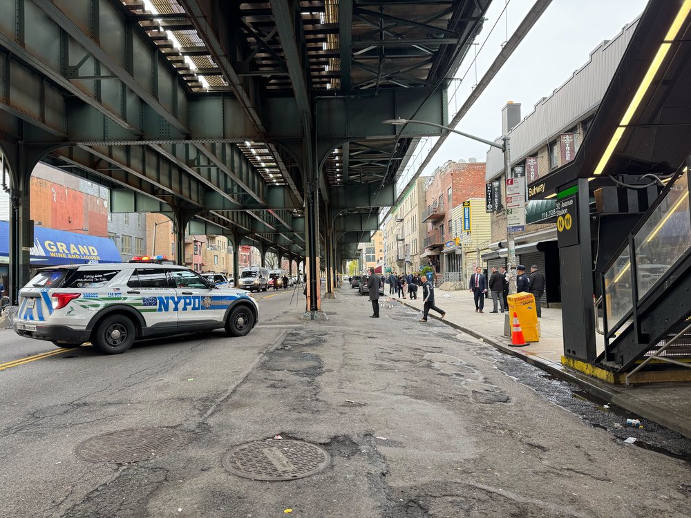 An NYPD cruiser and detectives are on the scene of a police shooting in Astoria on April 14, 2025.