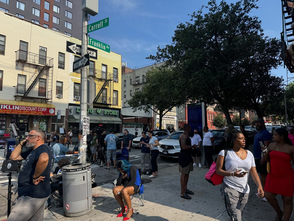 Community memers mourning following a mass shooting in Crown Heights.