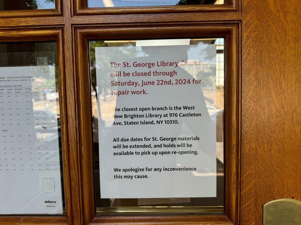 A sign posted to the door of the St. George library branch saying it will be closed until Saturday.