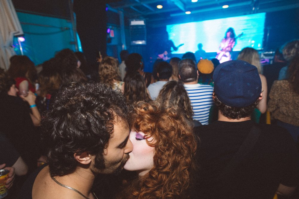 A group of people on the dance floor in a crowded club.