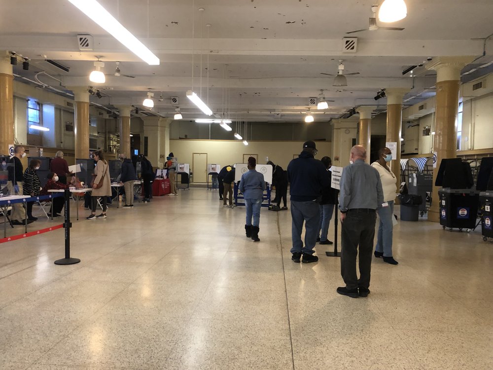 People assembled to cast voting in an election polling station.