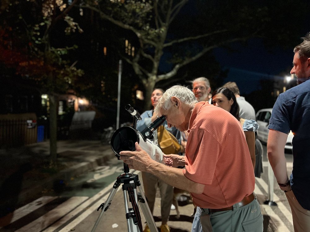 Joe Delfausse adjusts the telescope for his visitors to account for planetary rotation.