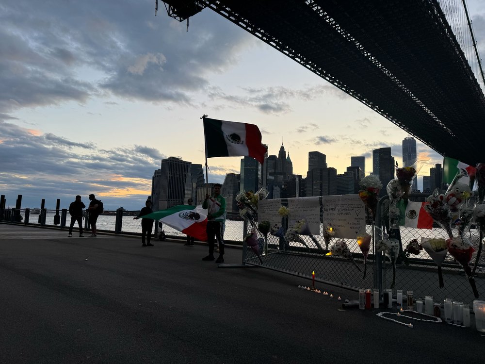 People visit a memorial set up for the victims of the Brooklyn Bridge ship strike under the Brooklyn side of the bridge on May 18, 2025.