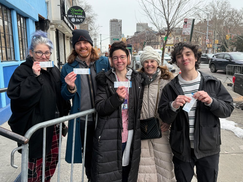 Five friends pose for the camera with their tickets to see Paul McCartney.