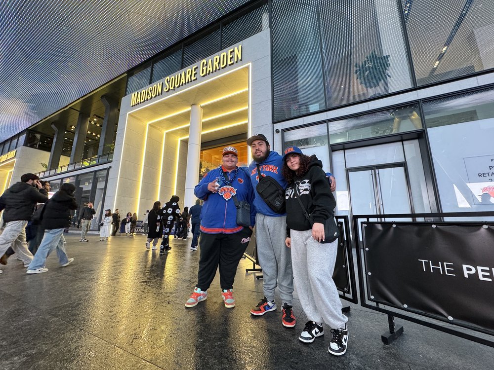 Three fans in Knicks gear outside of Madison Square Garden.
