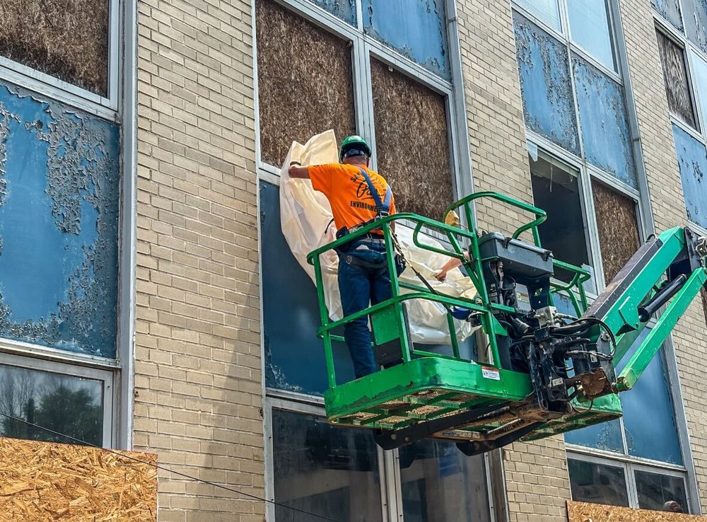 Construction workers seal the building to begin asbestos removal.