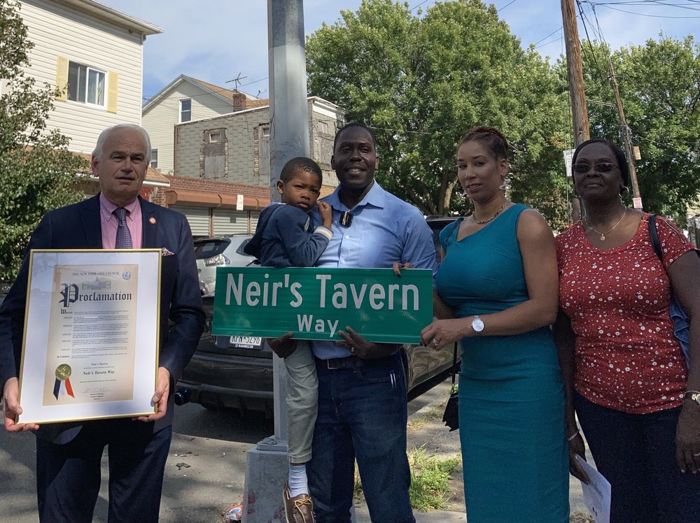 (l-r) Councilmember Robert Holden, Loycent Gordon and his family following the street co-naming ceremony in honor of Neir's Tavern.