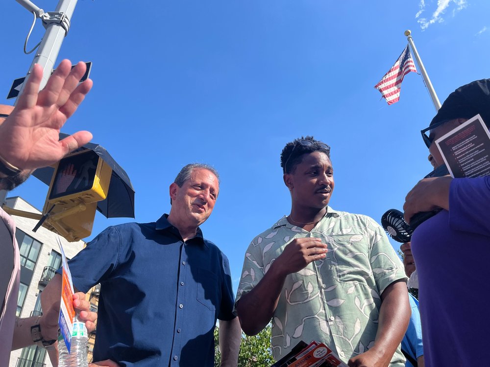 Politicians greet voters in the bright sun.