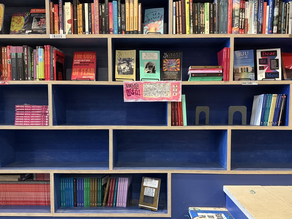 The interior of a bookstore with some empty shelves.