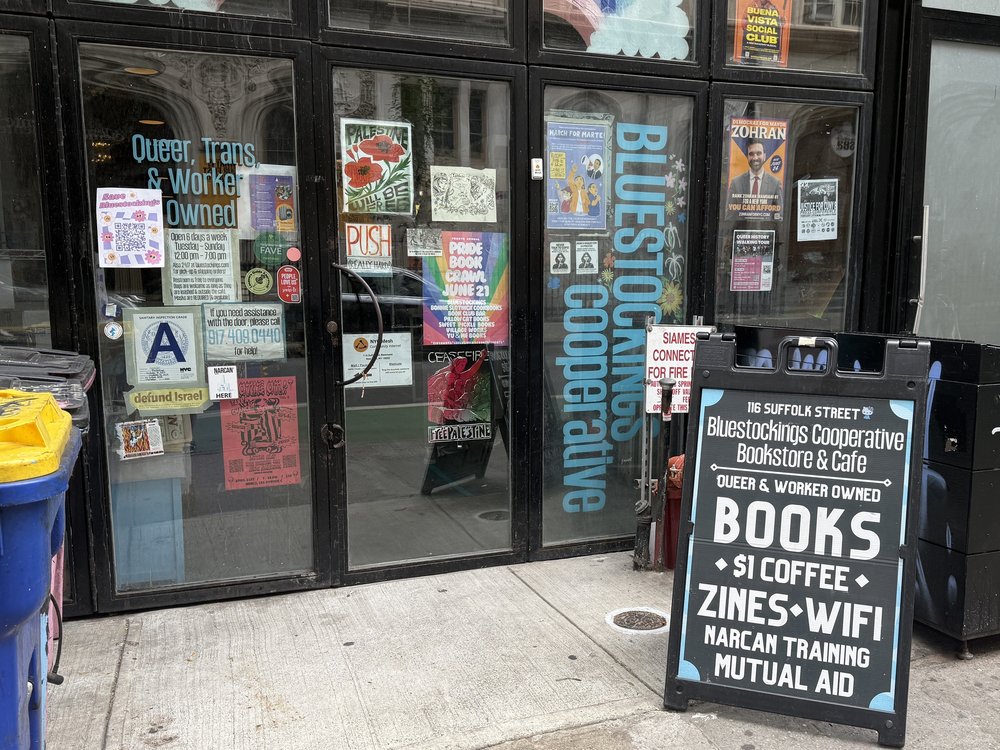 The exterior of a bookstore with a chalkboard sign in front.