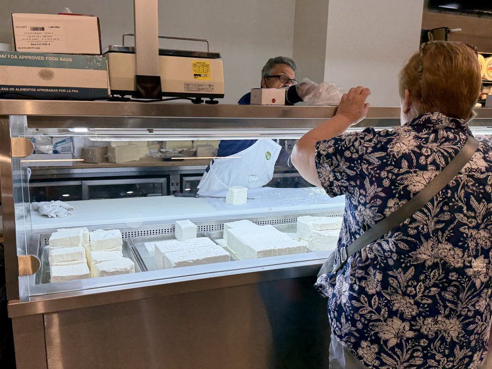 A shopper in line after Greek grocer Titan reopened in Astoria, two years after its previous closure.