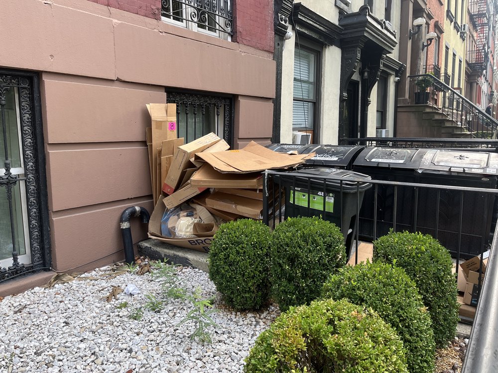 Broken down cardboard boxes by an apartment building.