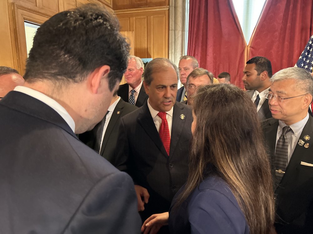 Politicians chat in a crowd.