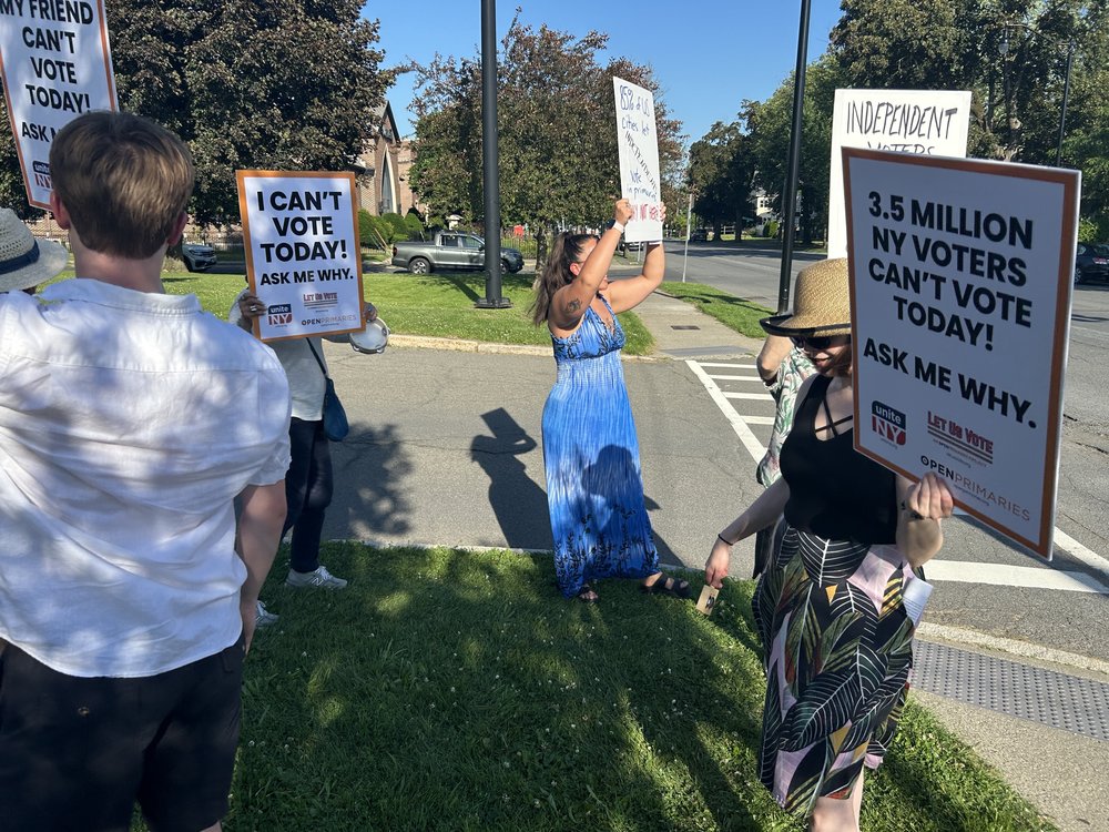 People organized by Unite NY demonstrate near an Albany polling place, seeking open primaries.