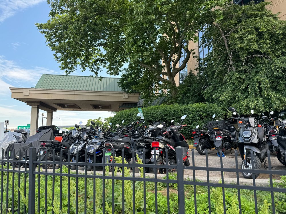Mopeds and scooters parked outside the hotel where NYPD officials said the suspect lives, on June 3, 2024.
