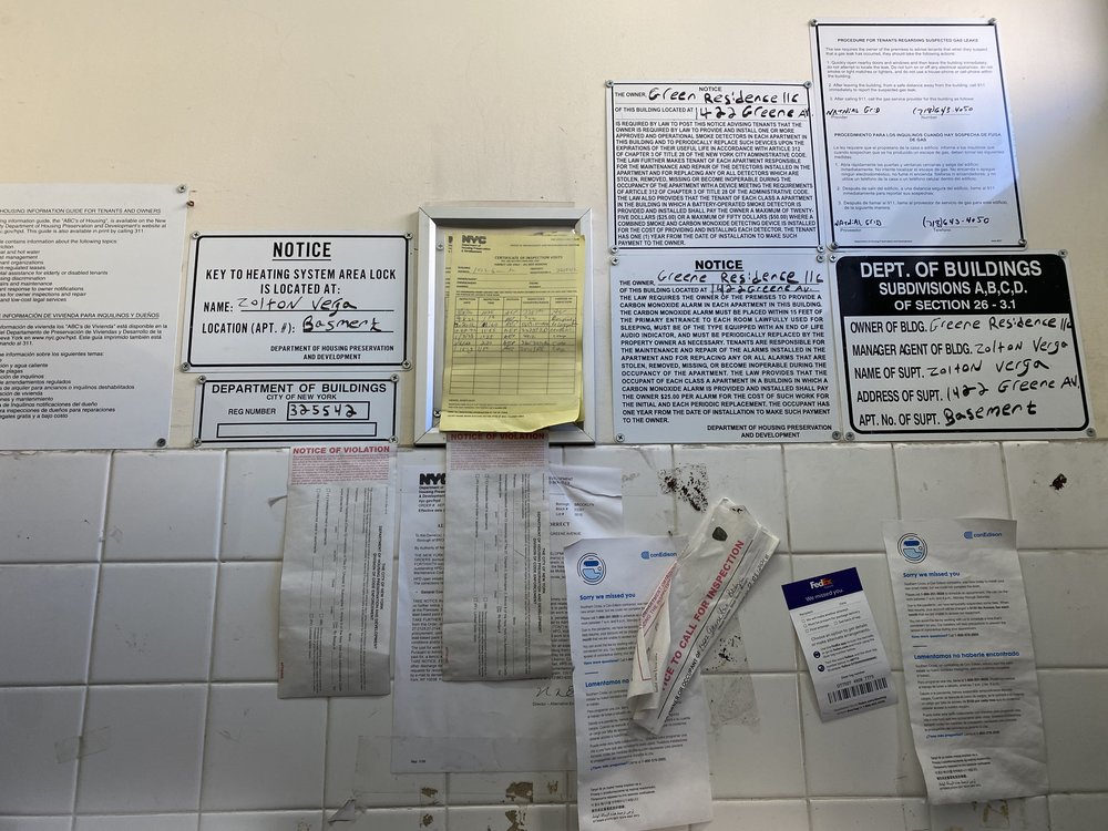 The lobby of 1422 Greene Ave is littered with notices and warnings about utility shutoffs.